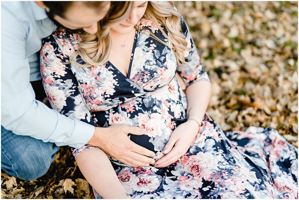 close up of mom and dad holding baby belly floral maxi maternity dress