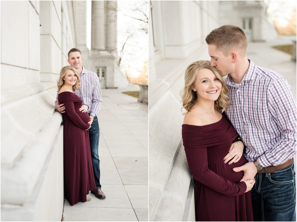 couple leaning on missouri state capitol building for maternity session in maroon dress