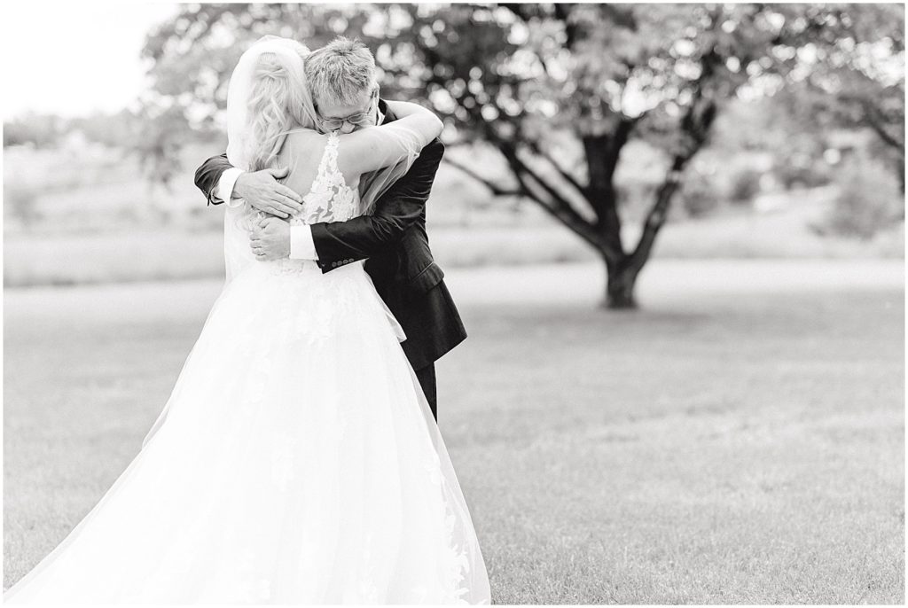 black and white image of bride and dad hugging