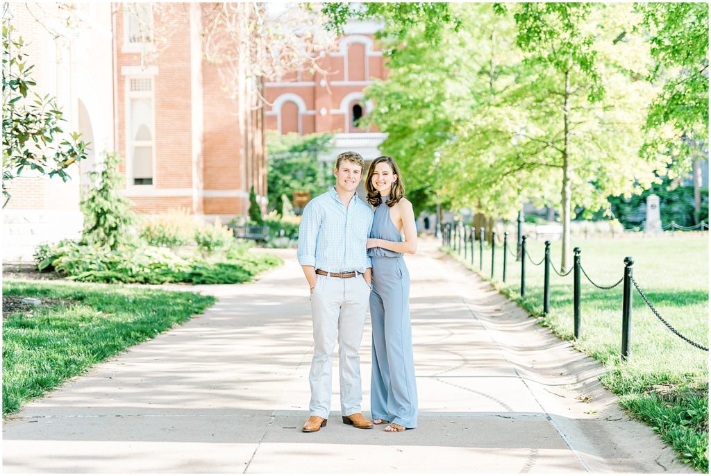 couple stands on sidewalk of mizzou campus for engagement pictures