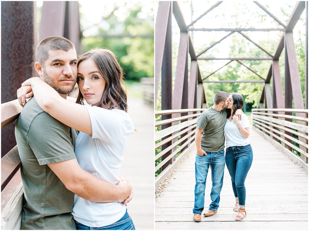 engaged couple stands on a bridge looking at camera