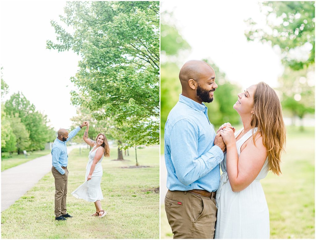 couple smiles at each other in front of tree during engagement pictures