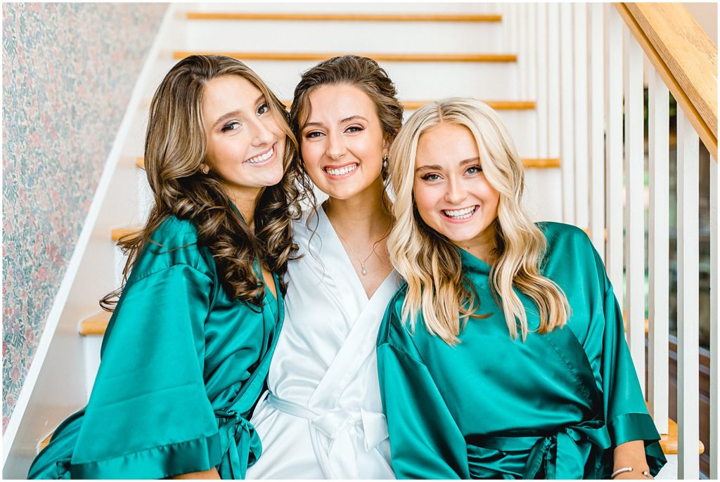 bride with her sisters wearing emerald robes on wedding day