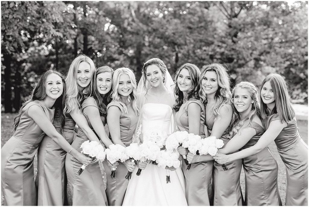 black and white image of bride and bridesmaids holding bouquets at les bourgeois winery wedding day