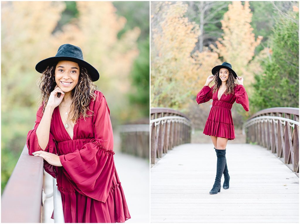 senior girl wearing large black hat and maroon mini dress and tall black boots while posing bridge during senior photos in Jefferson City, MO