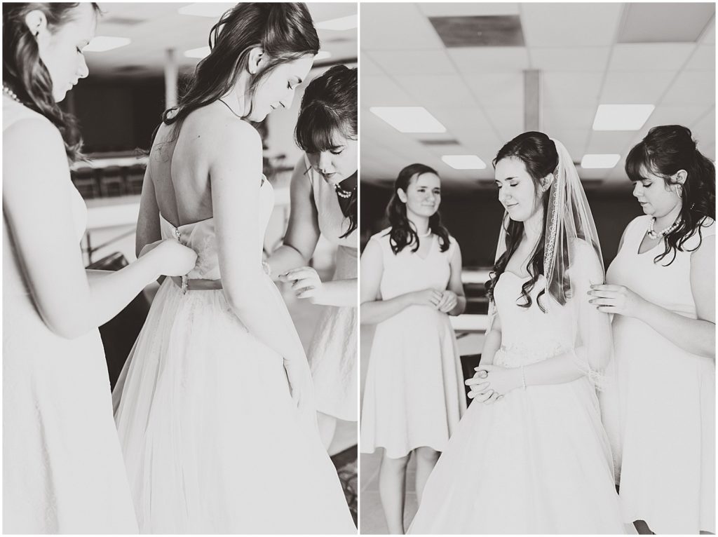 black and white bridesmaids helping bride get into dress