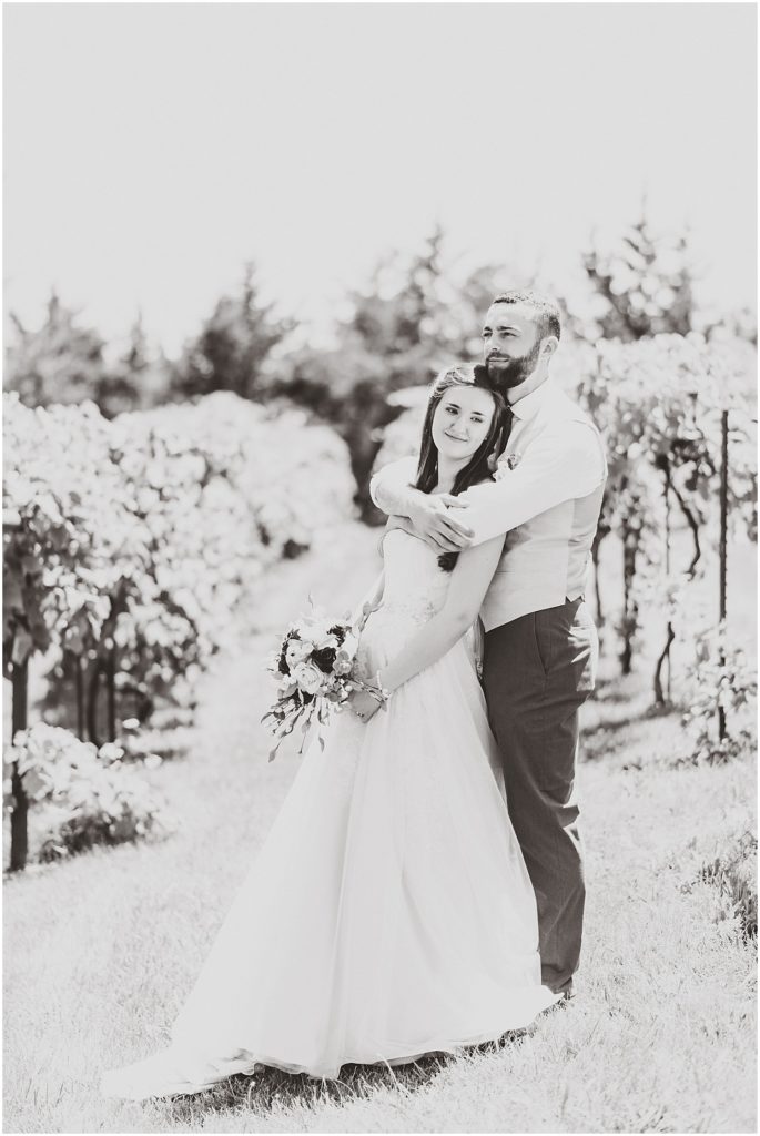 black and white bride and groom posing canterbury hill winery vineyard