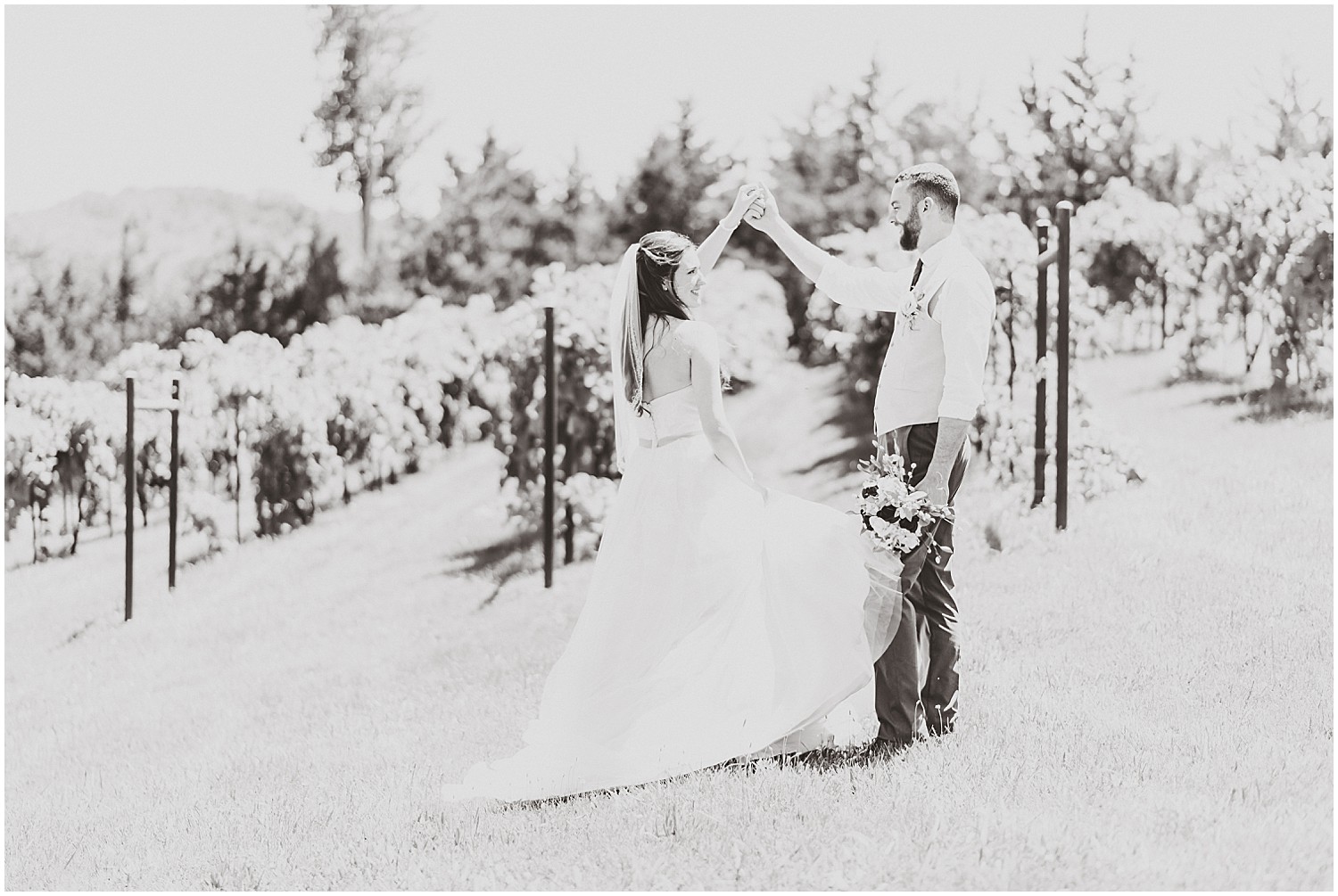 winery wedding bride and groom spinning by vineyard black and white