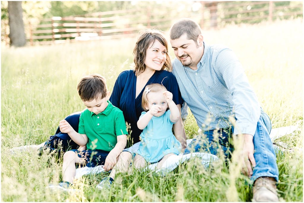 family sitting in grass snuggling family portrait session Westphalia, mo