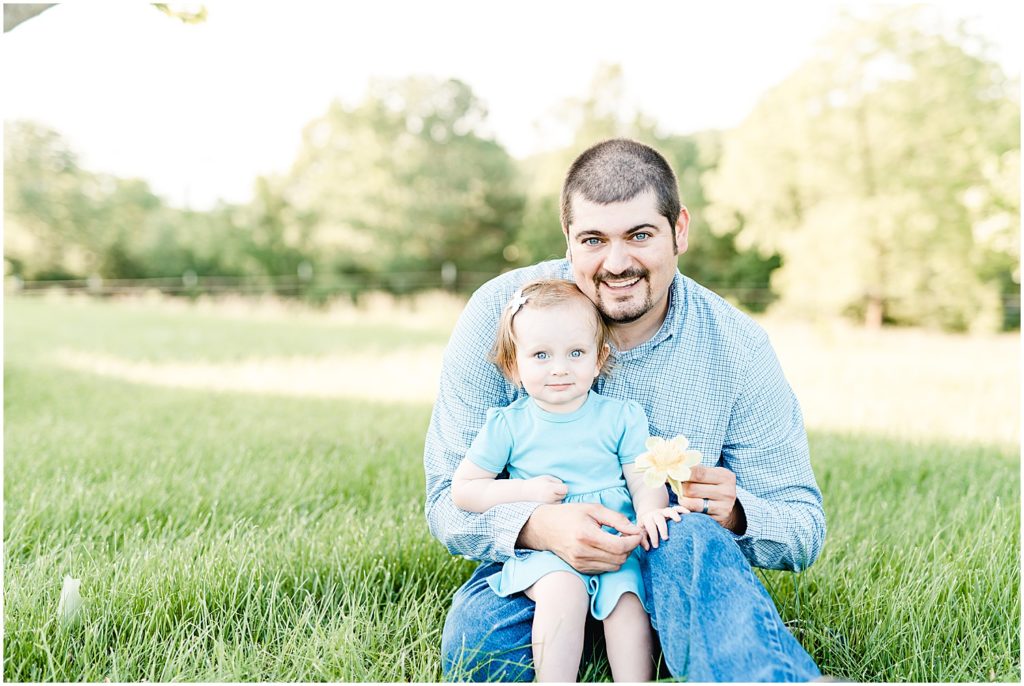 dad and daughter sitting in grass family portrait session