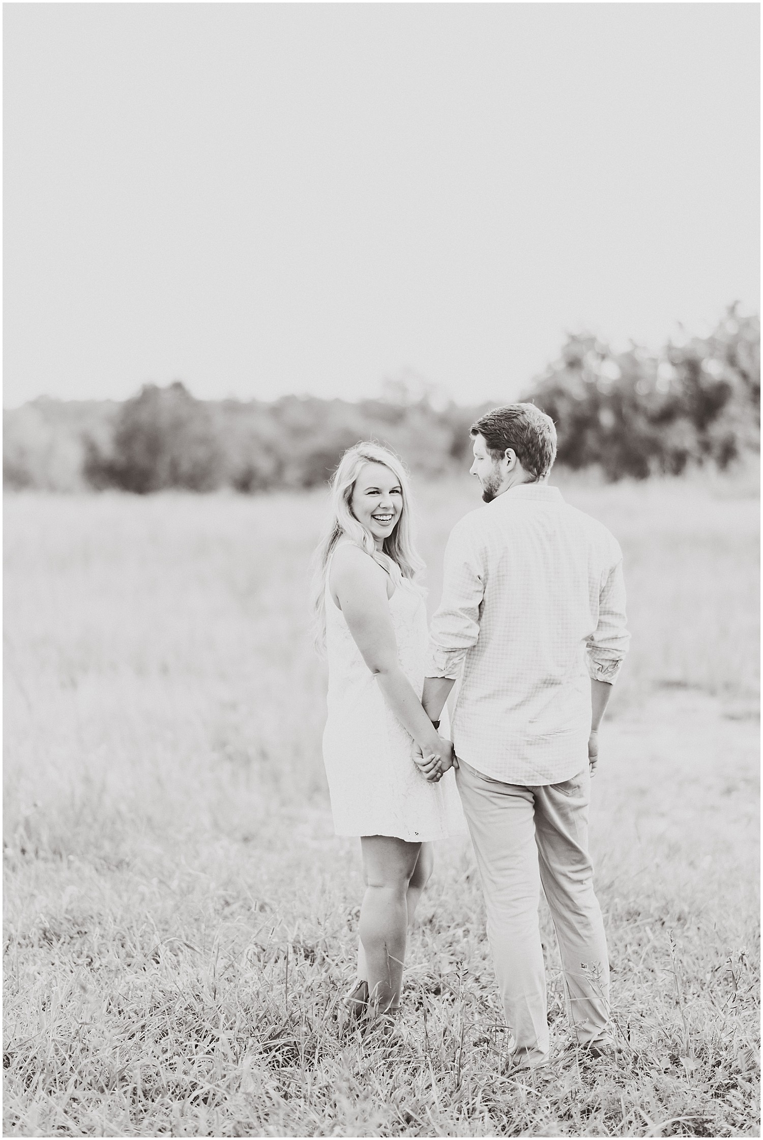 Cooper's ridge engagement session couple standing in field of grass