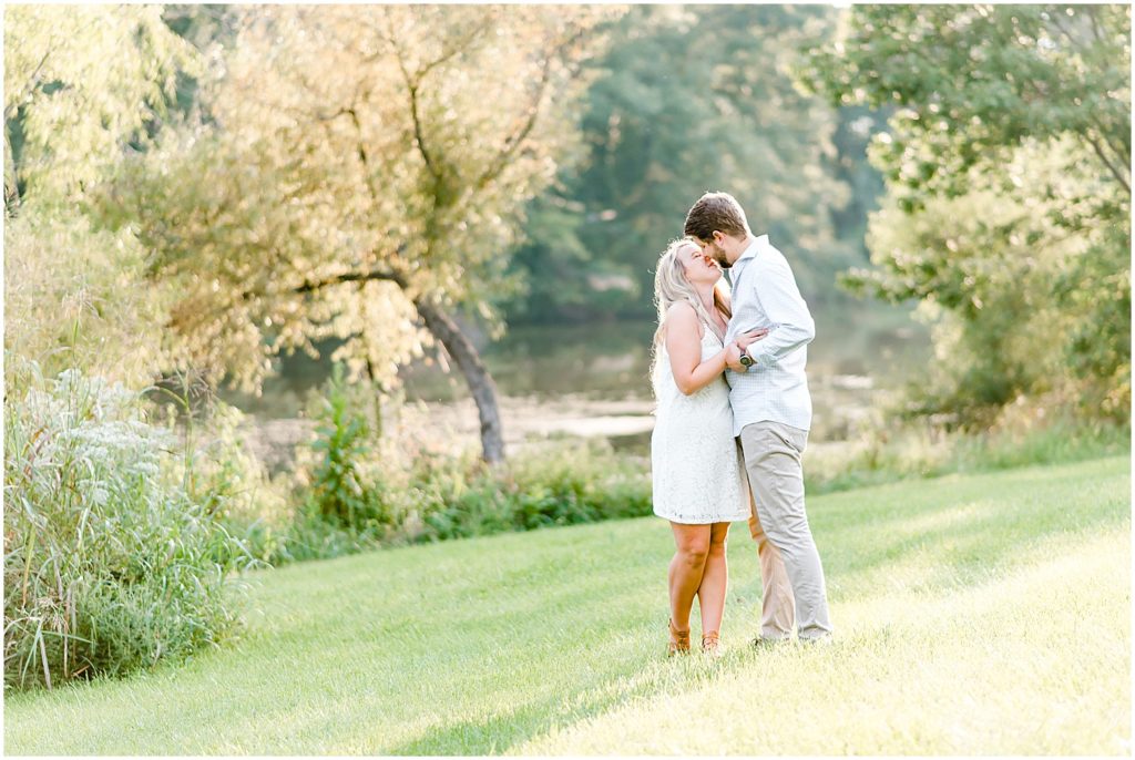Cooper's ridge engagement session couple standing in field of grass kissing