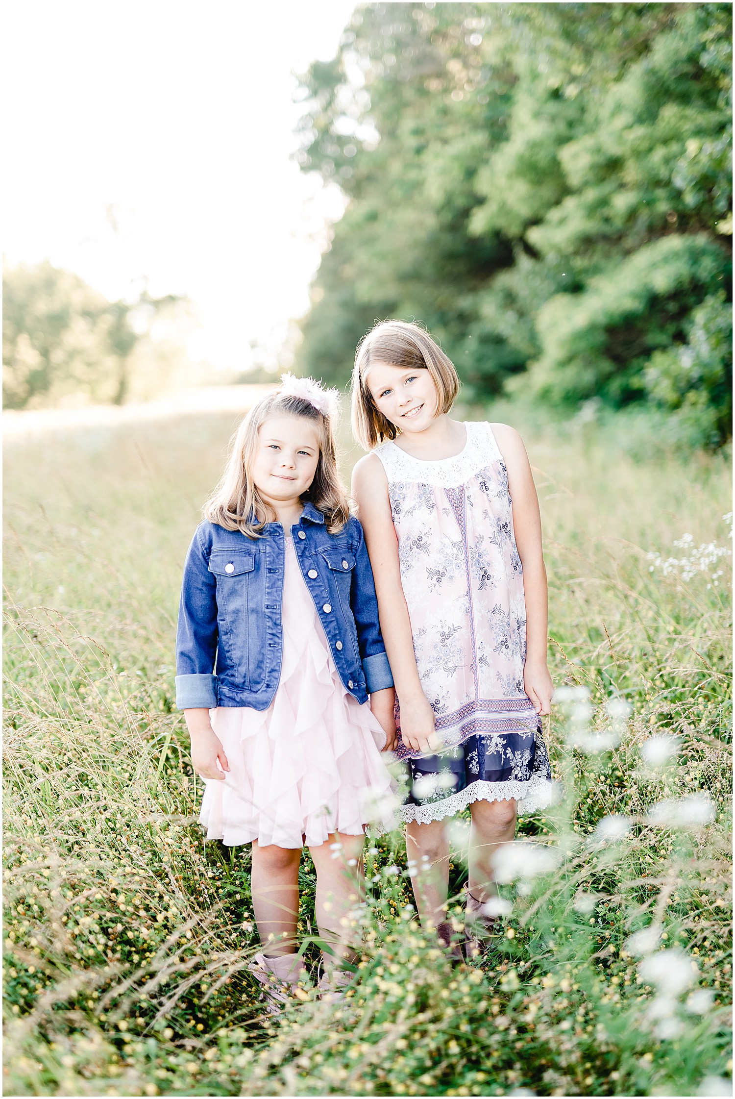 two sisters standing next to each other smiling at camera binder park family session