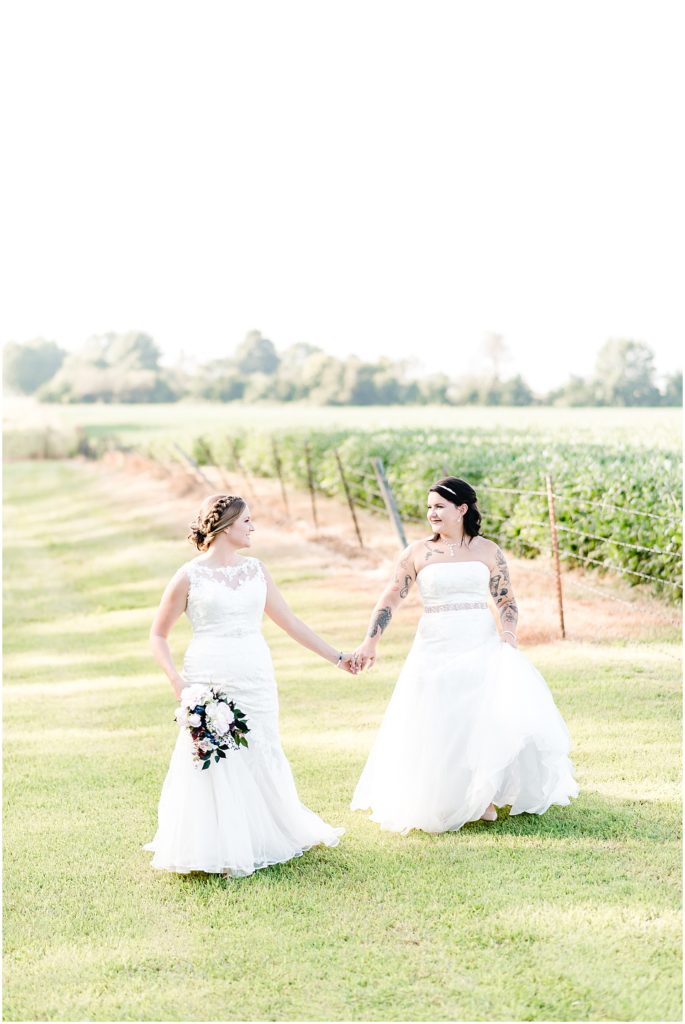 bridal portraits two brides walking by field