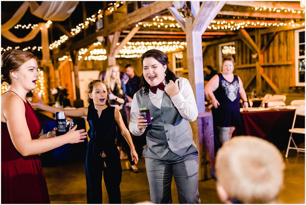 bride dancing in tux and singing barn wedding