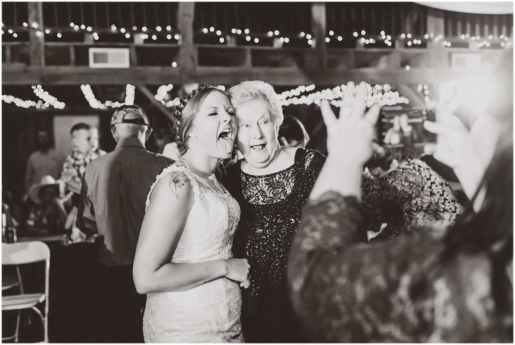 grandma taking picture with bride black and white sticking tongue out