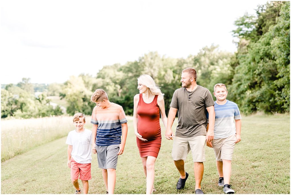 family of boys with pregnant mom walking toward camera