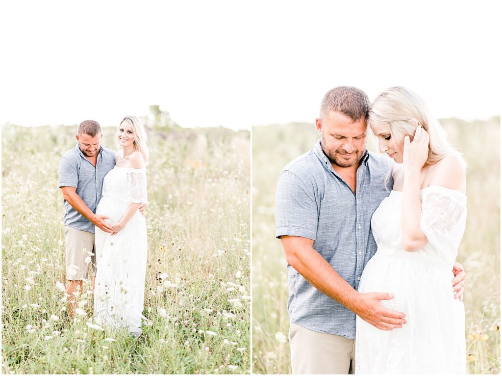 pregnant mom and dad standing in wildflower field snuggling