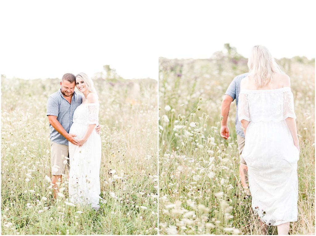 pregnant mom and dad white dress standing in wildflower field