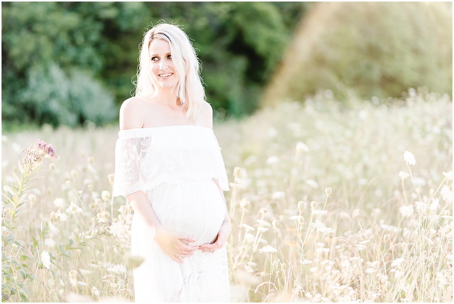 Blonde pregnant mom in white maternity dress wildflower fields