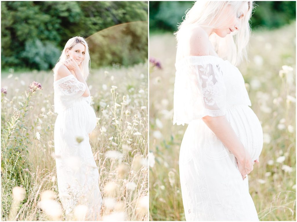 pregnant mom in long white dress standing in wildflower field holding belly