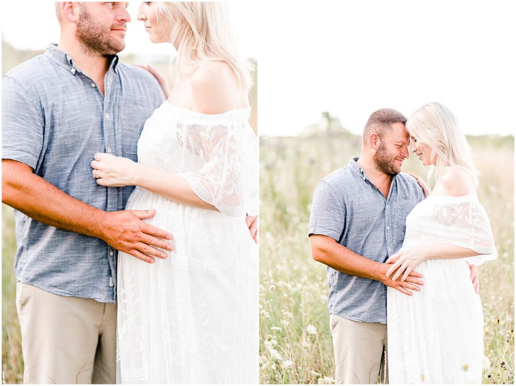 pregnant mom and dad nuzzling in wildflower field