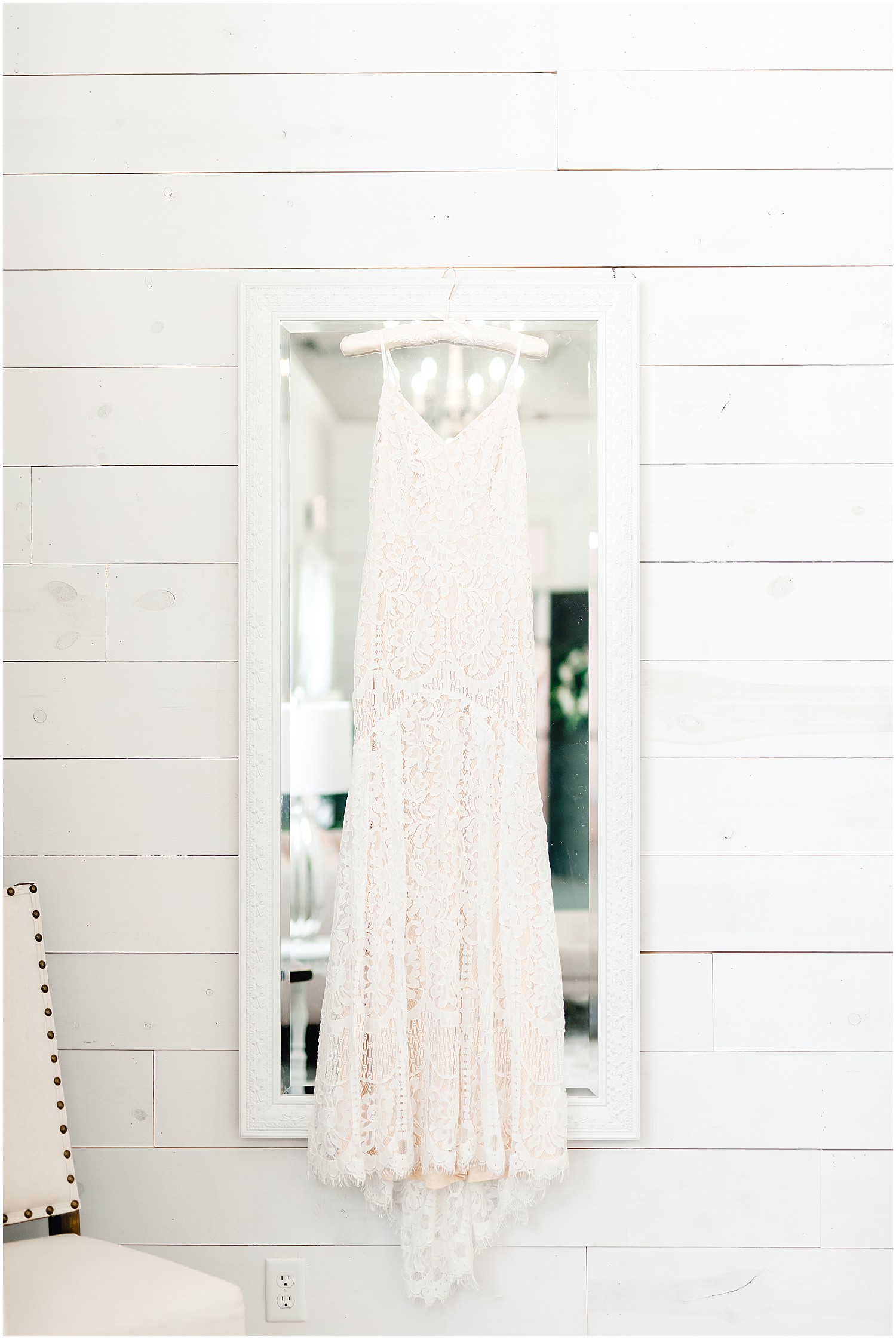 warehouse 55 bride and groom styled session dress hanging on mirror and bouquet