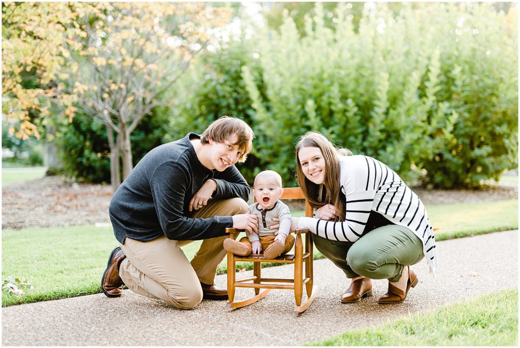 baby boy sitting in rocking chair with parents