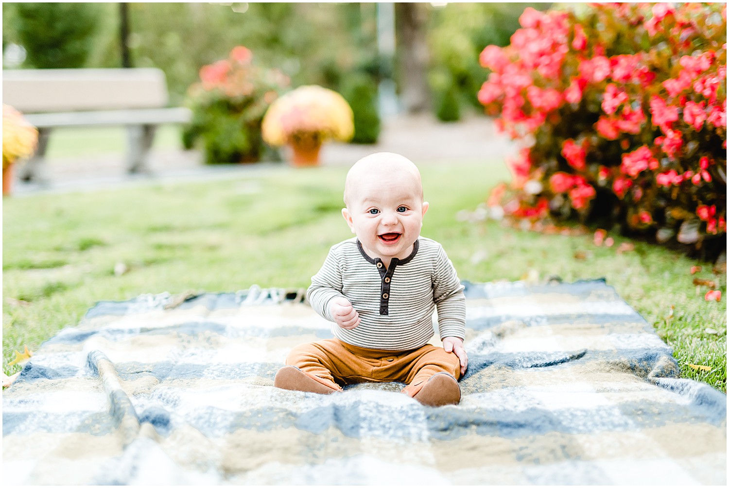 baby boy sitting up on blanket smiling