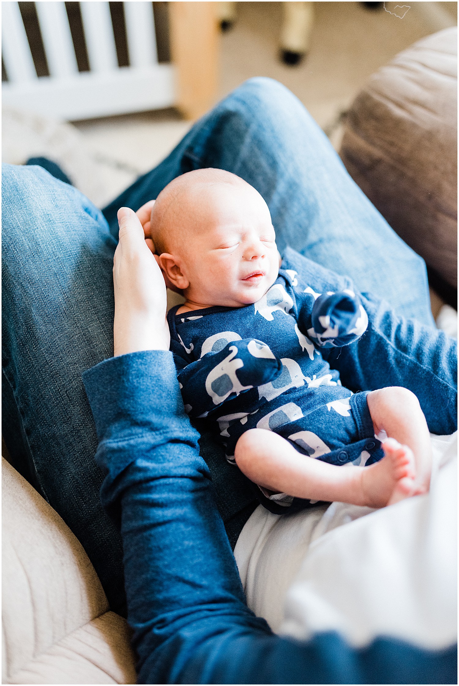 newborn baby sleeping on dads lap blue onesie