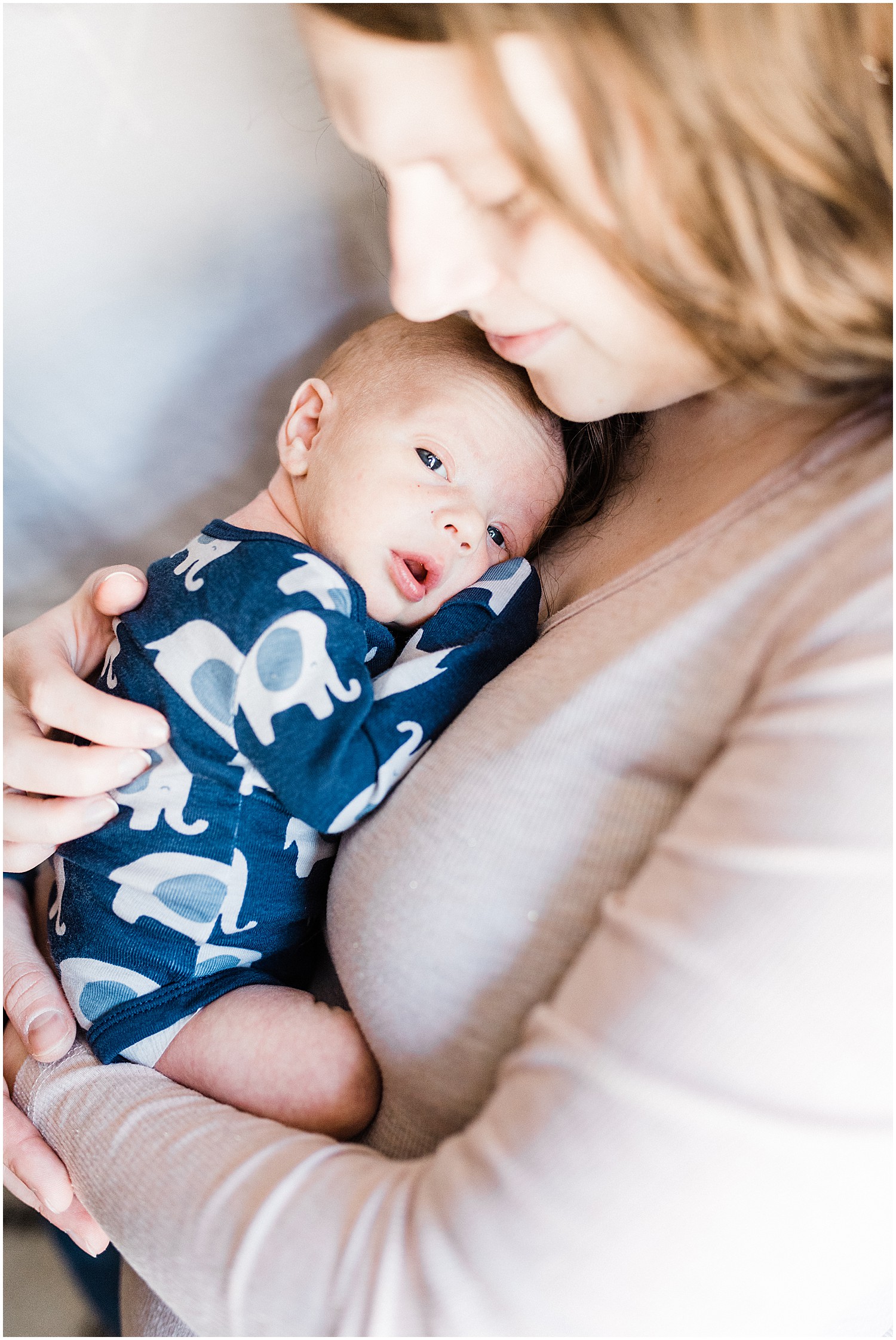 baby boy looking at camera mom holding newborn 