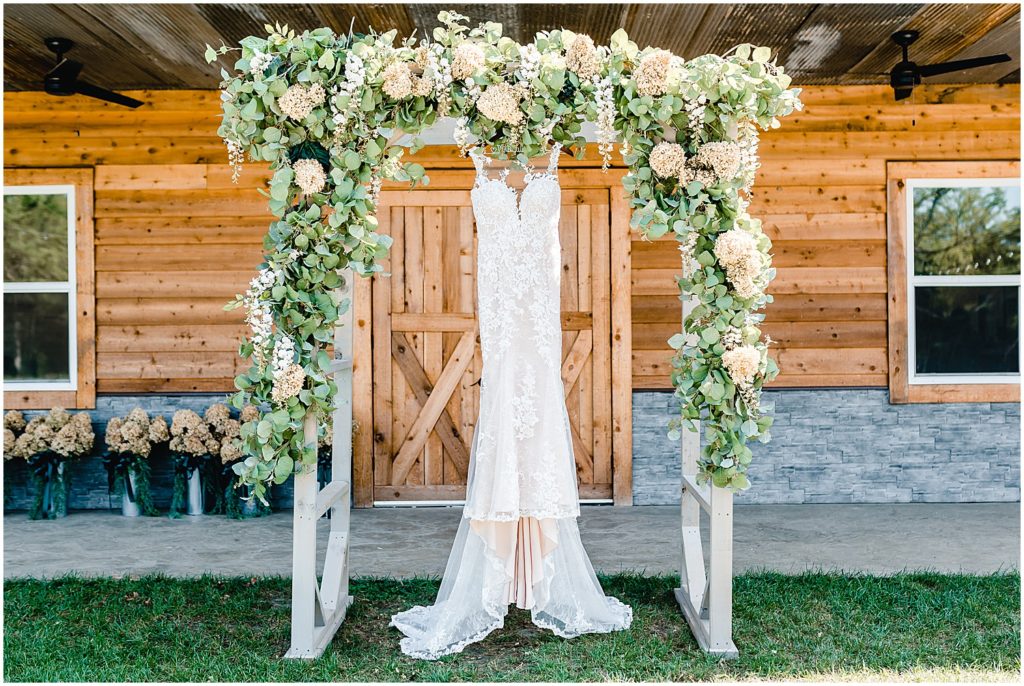 wedding gown hanging on altar outside barn
