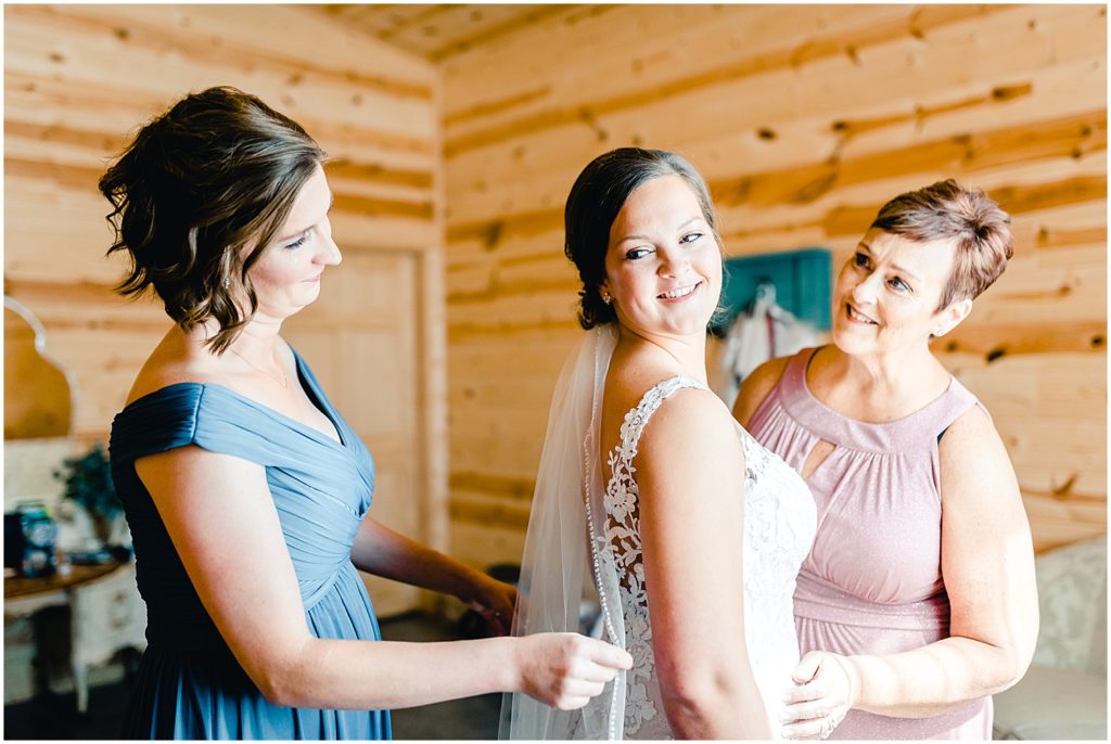 bride getting ready with mom and sister barn