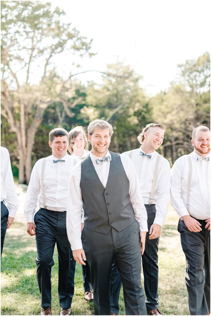 groom laughing at camera wedding party portraits
