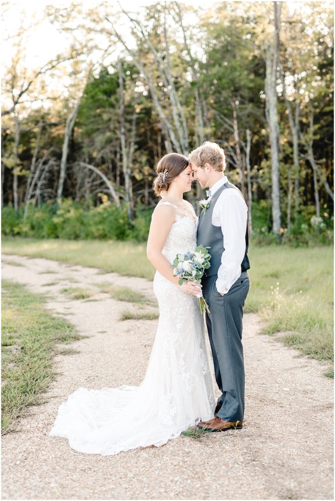 bride and groom portraits gravel drive woods trees barn at honeysuckle farms wedding