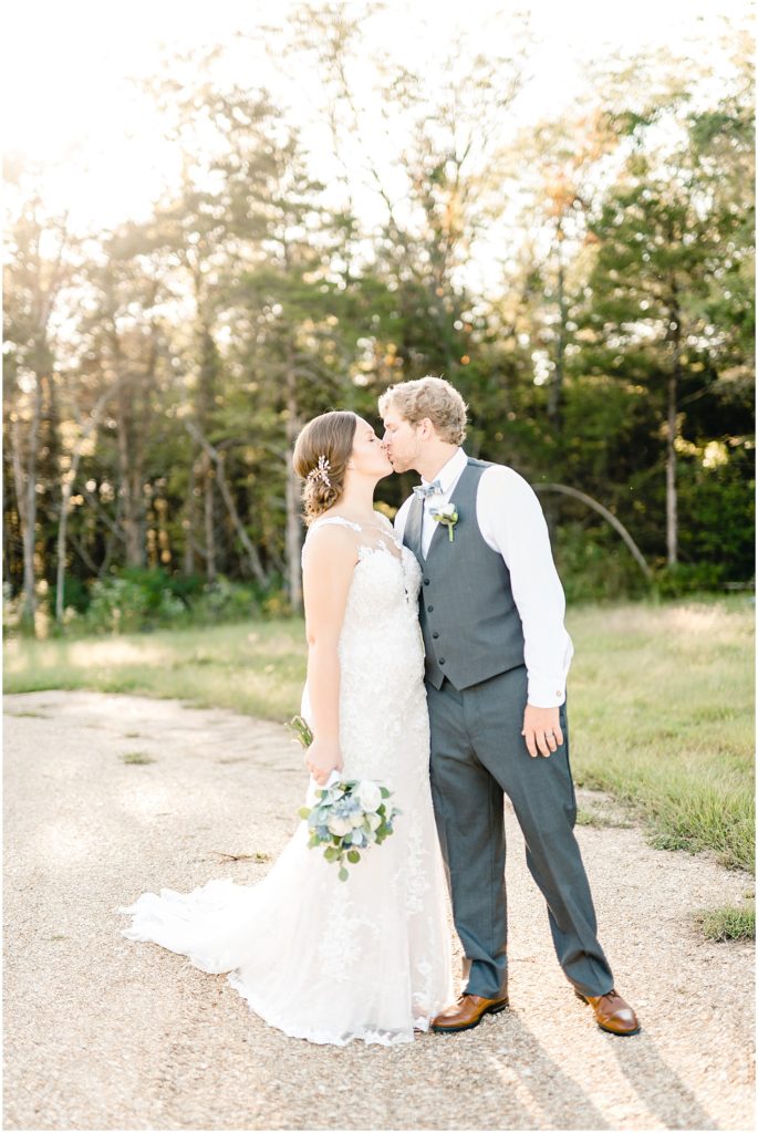 bride and groom portraits kissing sunlight gravel drive