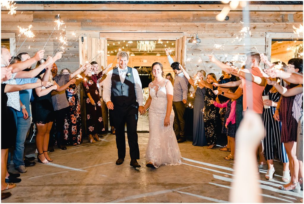 bride and groom under sparklers barn at honeysuckle farms wedding