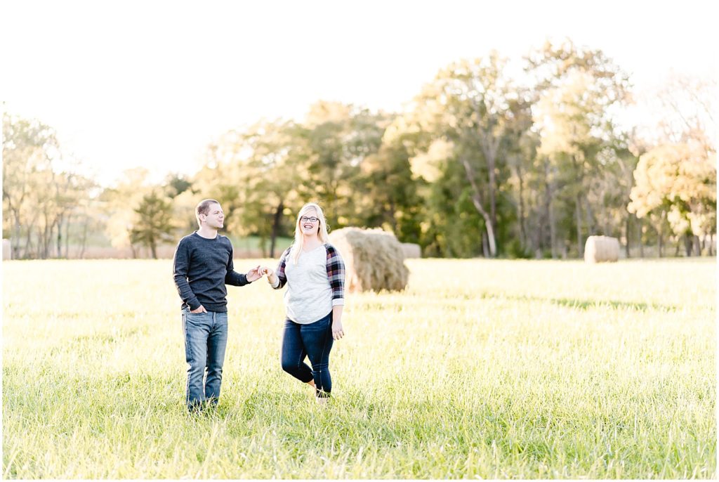 couple smiling and dancing in field kempker's back 40 engagement session