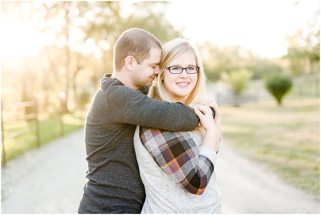 couple snuggling smiling at camera engagement session