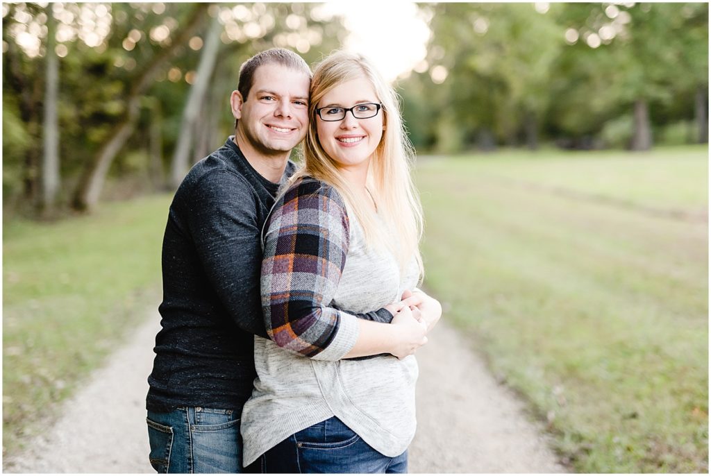couple holding hands hugging smiling engagement session