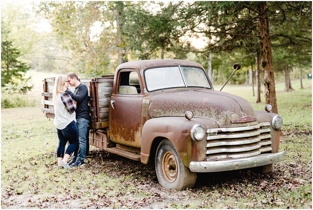 couple leaning against old truck engagement session
