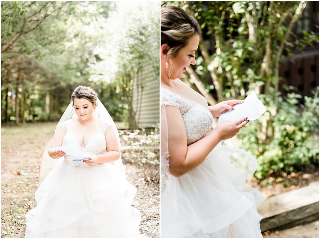 bride reading letter in gown under trees