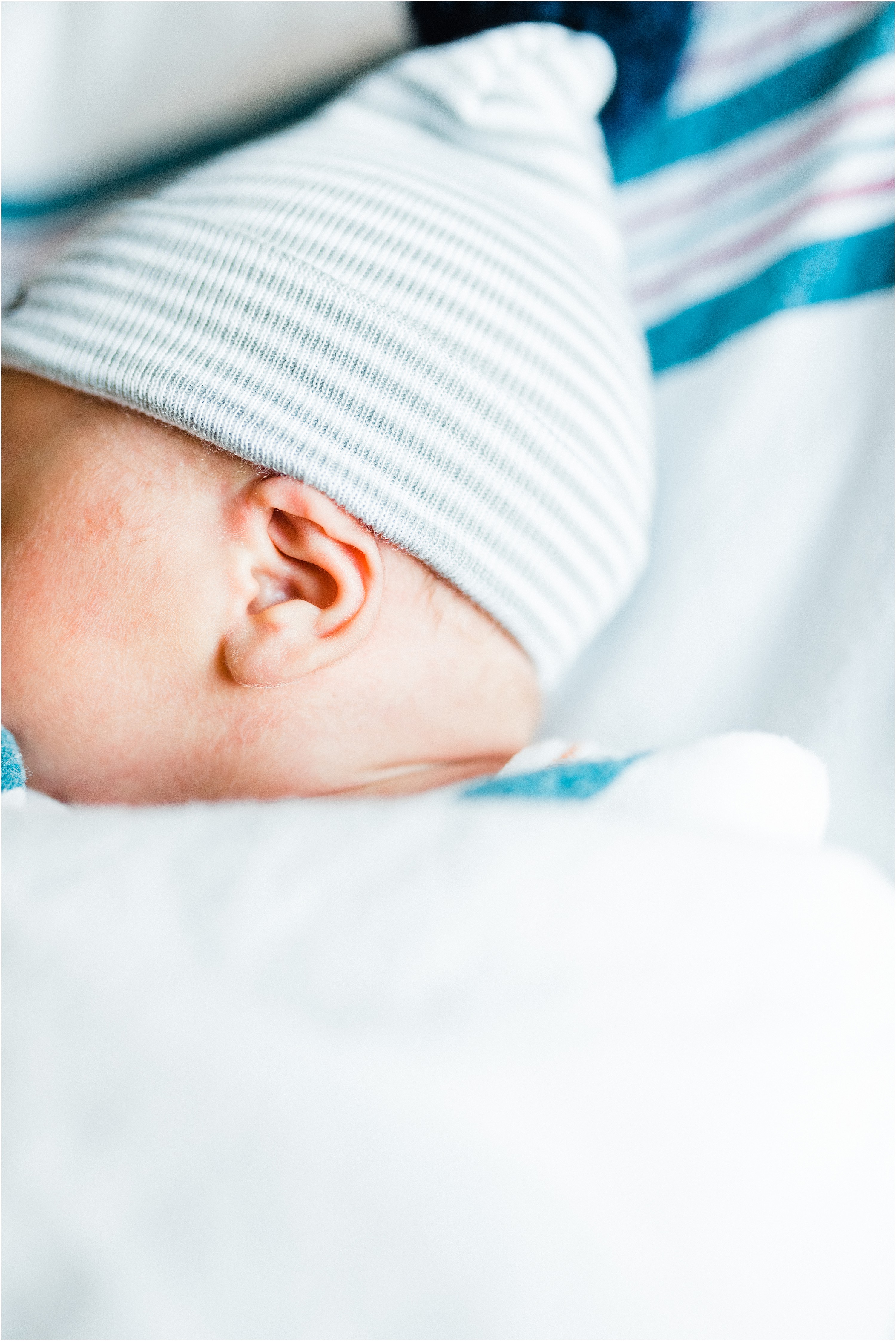 newborn baby ear with blue hat on