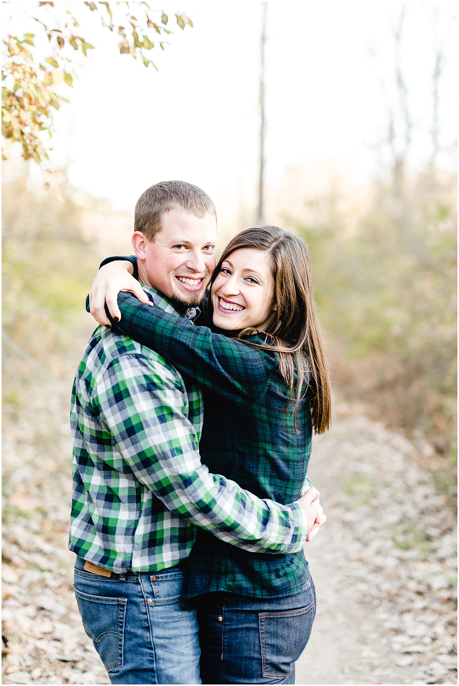 couple hugging and smiling at camera engagement session capen park