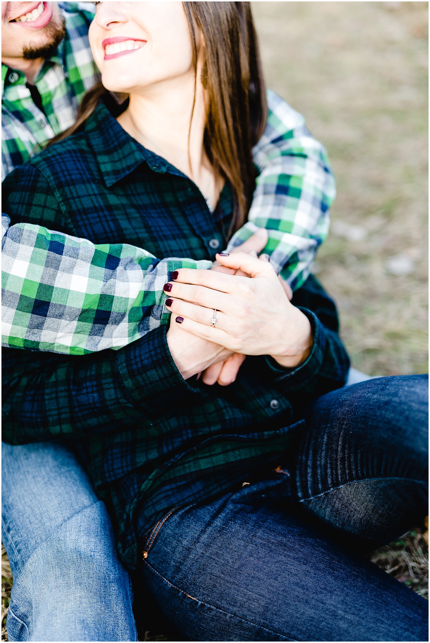 couple holding each other ring shot smiling engagement session