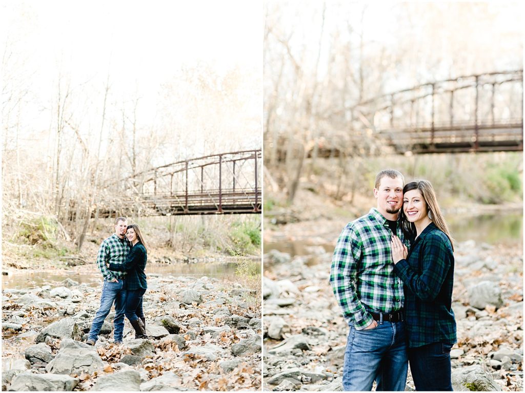 couple smiling at camera in creek bed capen park bridge engagement session