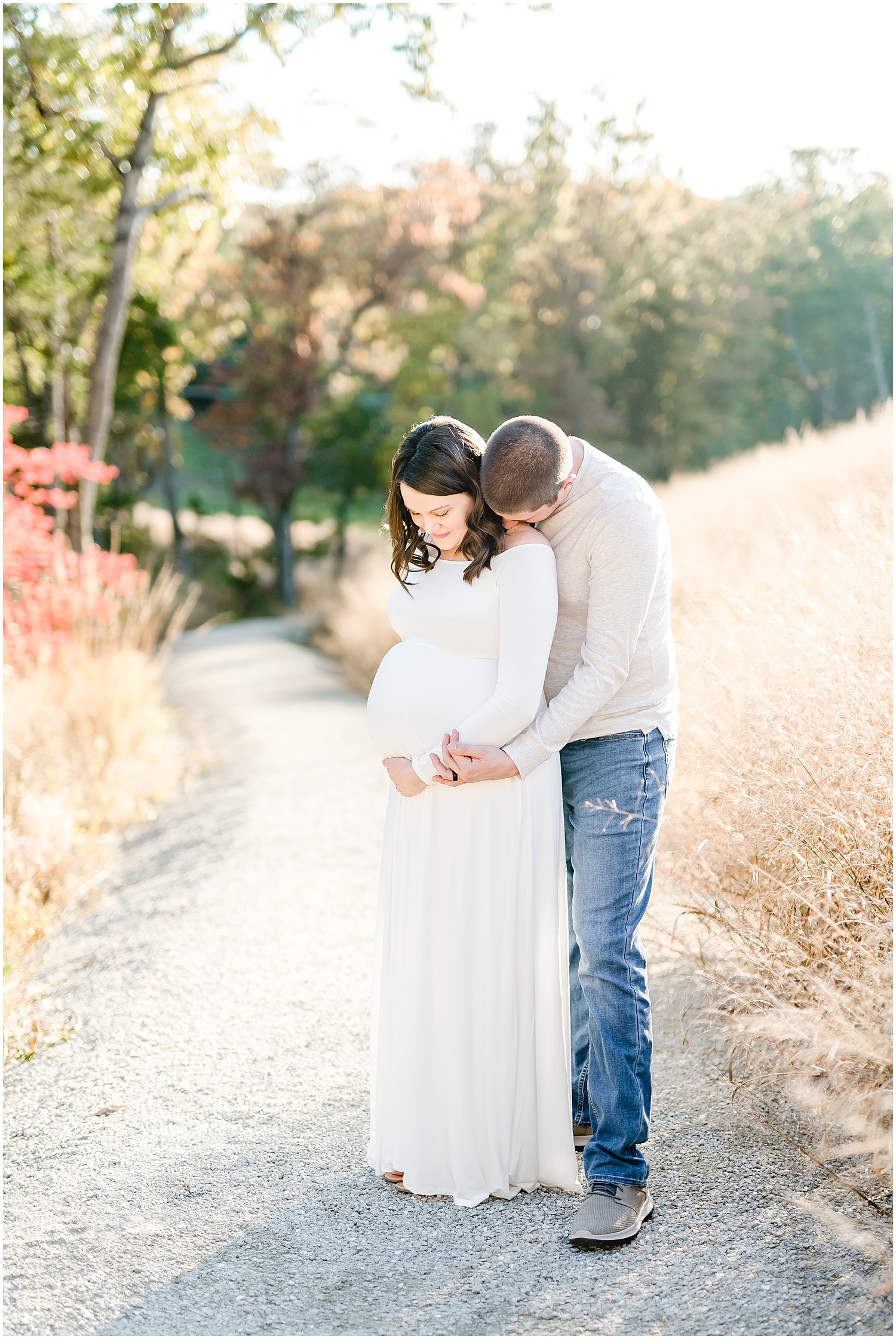 mom and dad holding baby belly fall field maternity session