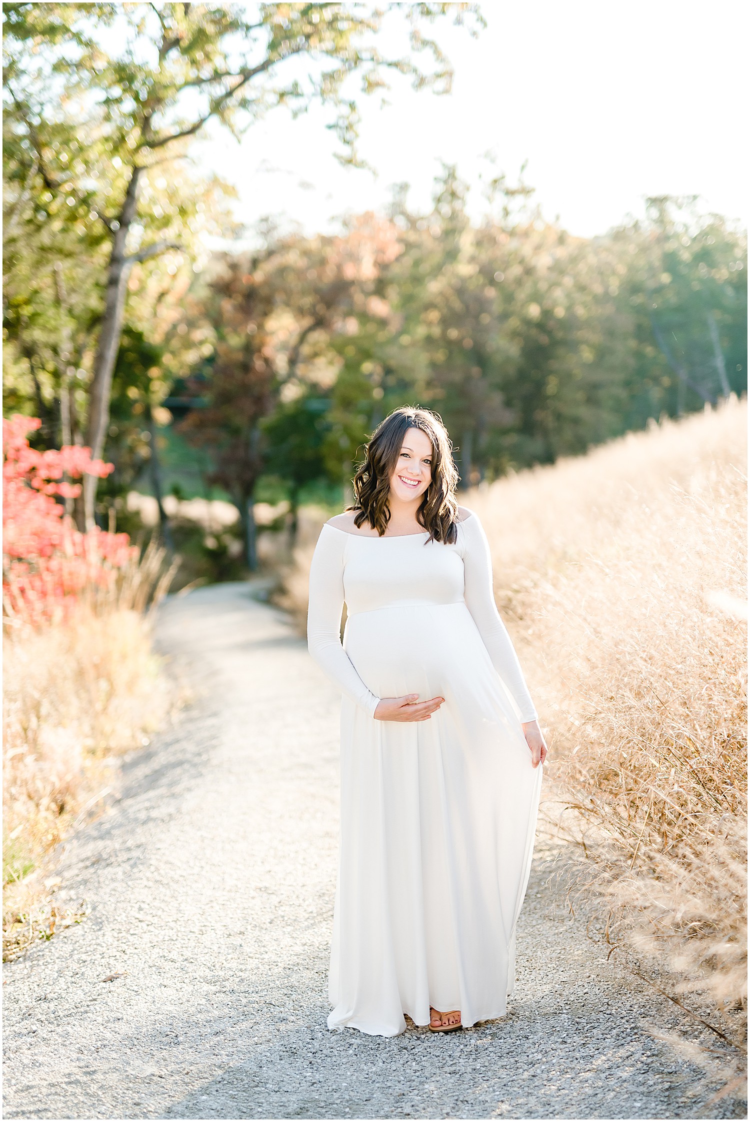 expecting mom in white dress laughing holding belly