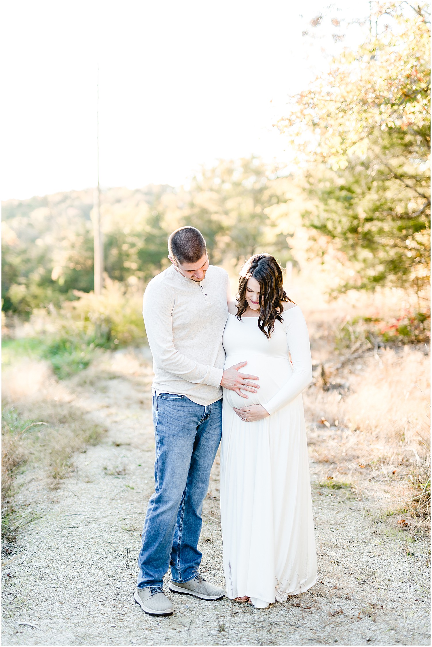 couple holding baby belly white maternity dress
