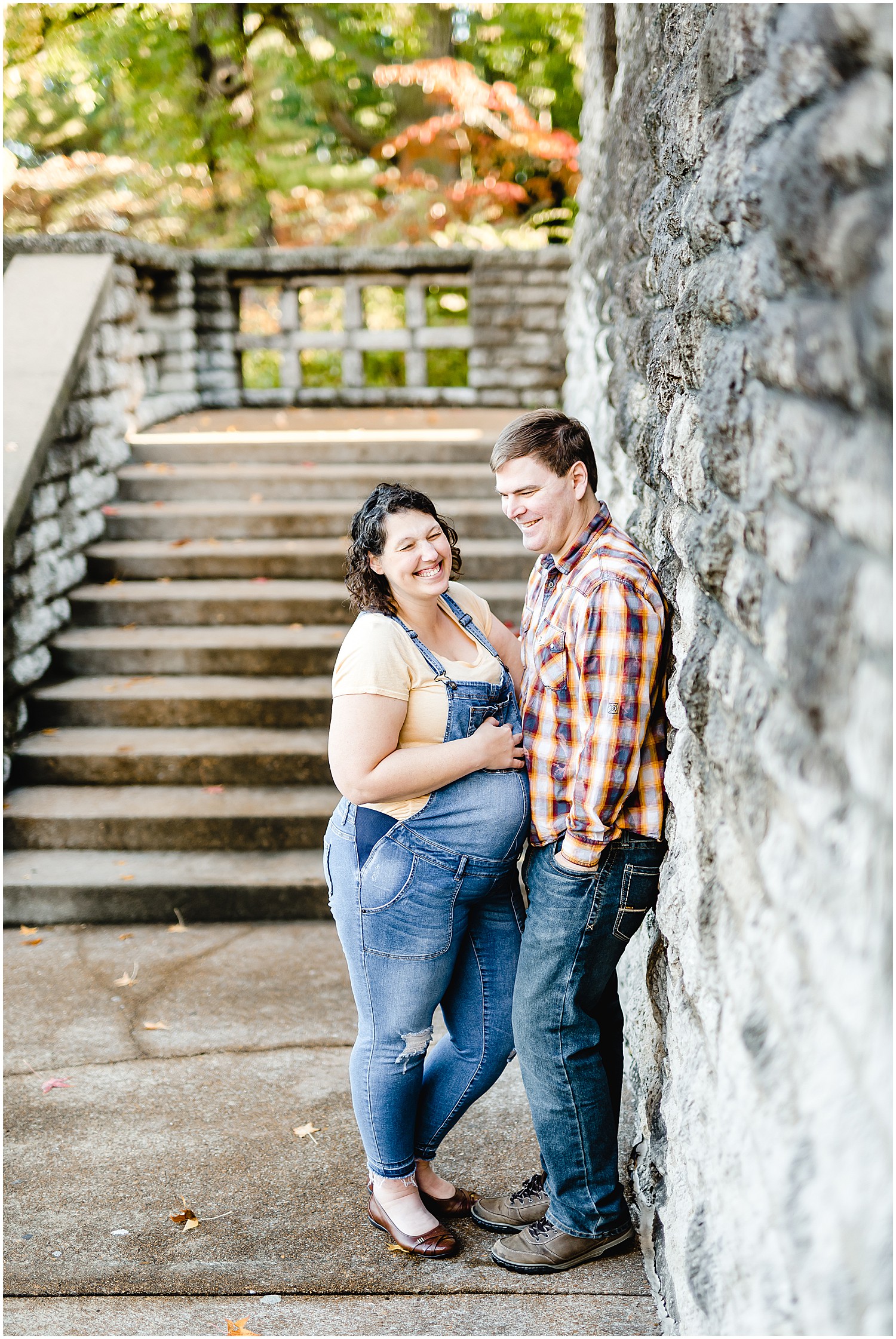 pregnant mom and dad leaning on rocks laughing maternity session